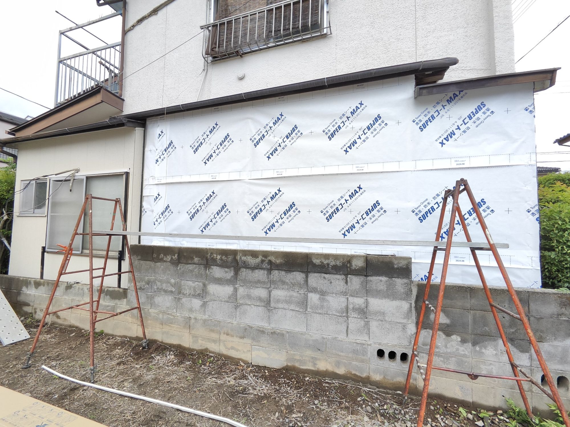 下地を整えて防水透湿シートを張り、左側よりサイディングを張って行く様子